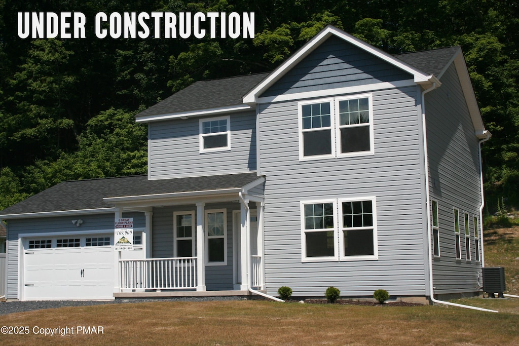 view of front of home featuring cooling unit, a garage, covered porch, and a front yard