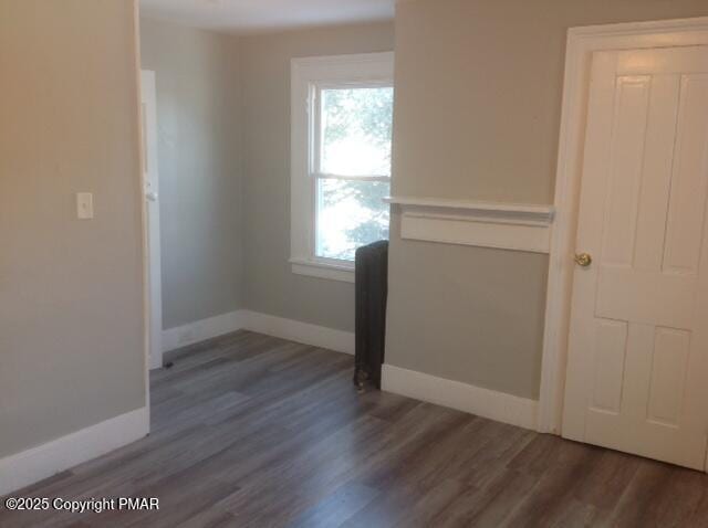 empty room featuring baseboards and wood finished floors