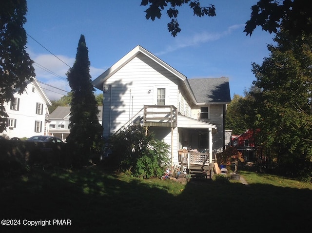 rear view of house featuring a lawn