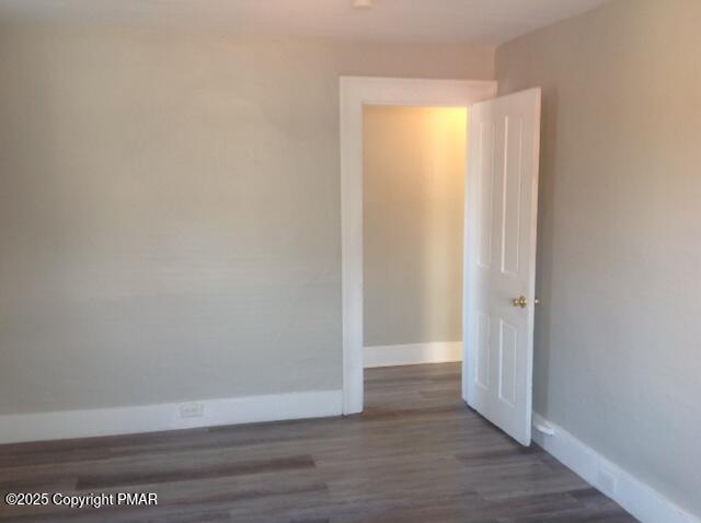 empty room with baseboards and wood finished floors