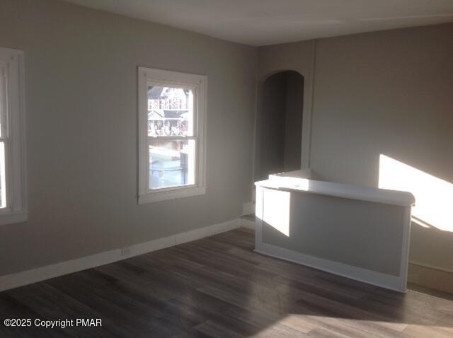 unfurnished room featuring baseboards and wood finished floors