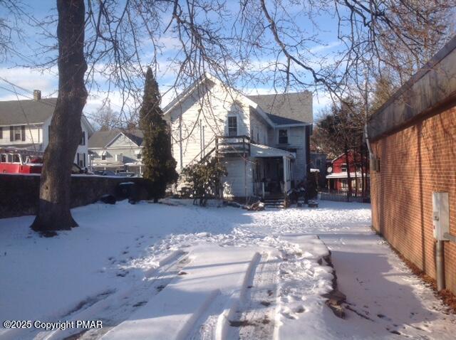 view of snowy exterior with fence