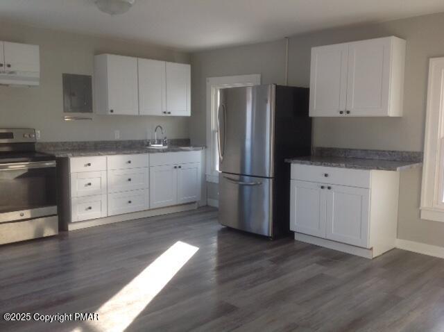 kitchen featuring sink, appliances with stainless steel finishes, white cabinetry, range hood, and dark hardwood / wood-style floors