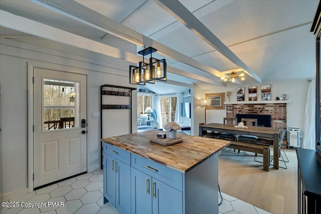 kitchen with open floor plan, butcher block countertops, plenty of natural light, and vaulted ceiling with beams