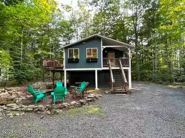 view of playground featuring an outdoor fire pit, stairway, and a wooden deck