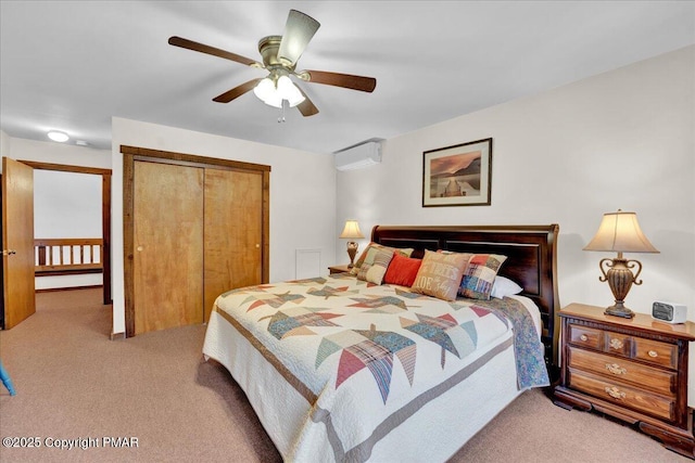 bedroom with a closet, light carpet, ceiling fan, and a wall mounted air conditioner