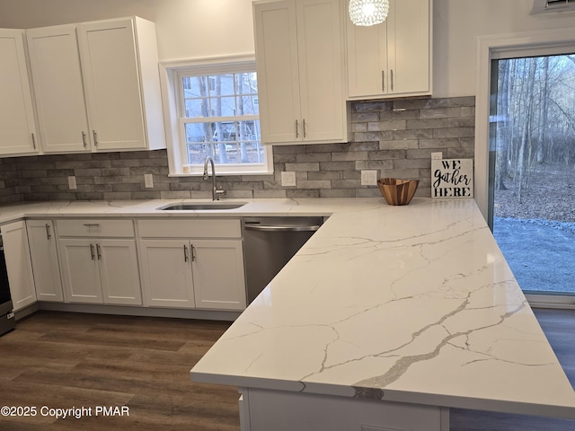 kitchen with a sink, light stone counters, stainless steel dishwasher, white cabinetry, and dark wood-style flooring