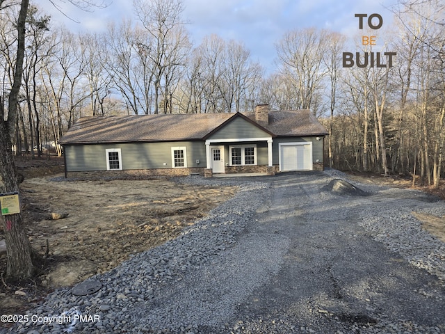 view of front of property with driveway, a chimney, a garage, and a shingled roof