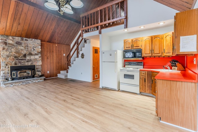 kitchen featuring brown cabinetry, wood ceiling, a sink, light wood-type flooring, and white appliances