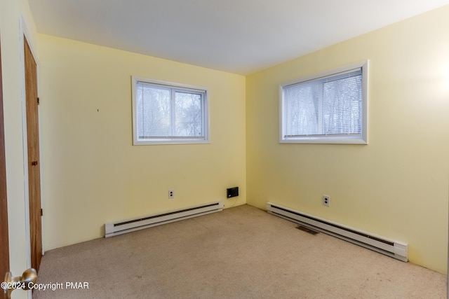 spare room featuring carpet floors and a baseboard radiator