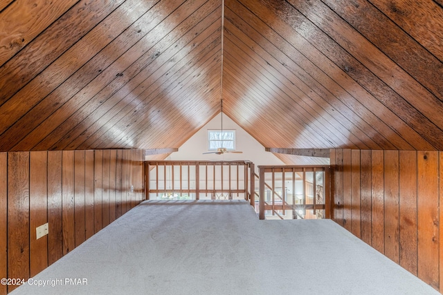 bonus room with lofted ceiling, carpet floors, and wooden walls