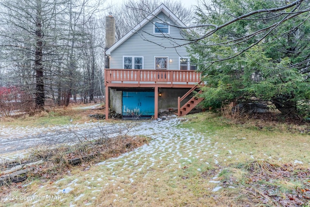 rear view of house with a chimney, stairway, and a wooden deck