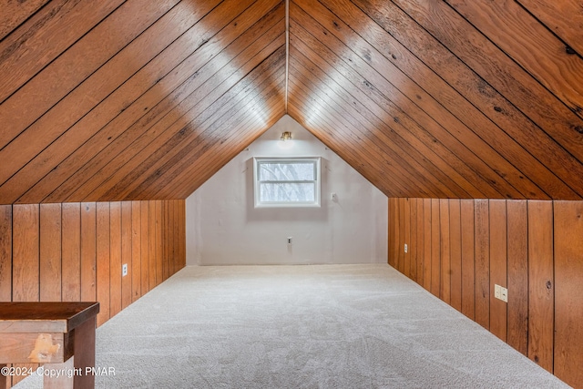 bonus room with lofted ceiling, carpet flooring, and wooden walls