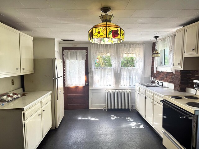 221 Diamond St, Pen Argyl, PA 18072 - kitchen with white appliances, radiator, light countertops, hanging light fixtures, and white cabinets