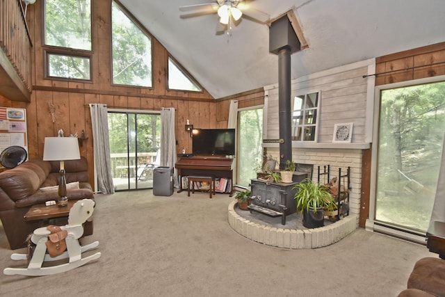 118 Sussex Ct, Bushkill, PA 18324 - living area with a wood stove, wooden walls, high vaulted ceiling, carpet floors, and a baseboard radiator