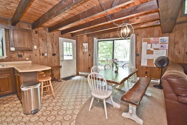118 Sussex Ct, Bushkill, PA 18324 - dining room featuring a wooden ceiling with exposed beams, a baseboard heating unit, wood walls, a chandelier, and light colored carpet