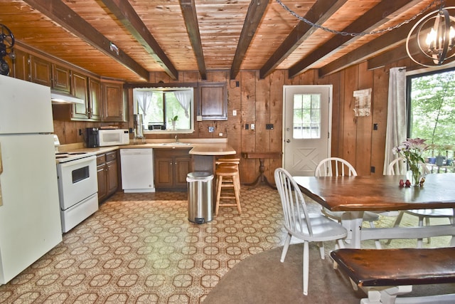 118 Sussex Ct, Bushkill, PA 18324 - kitchen with white appliances, a wood ceiling with exposed beams, wood walls, healthy amount of natural light, and light countertops