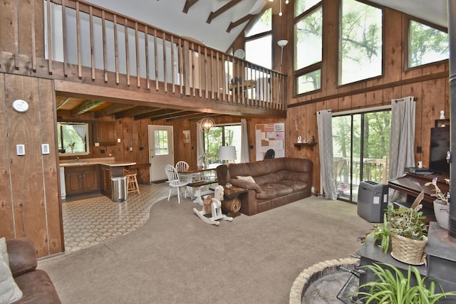 118 Sussex Ct, Bushkill, PA 18324 - living area with wood walls, plenty of natural light, high vaulted ceiling, carpet flooring, and beam ceiling