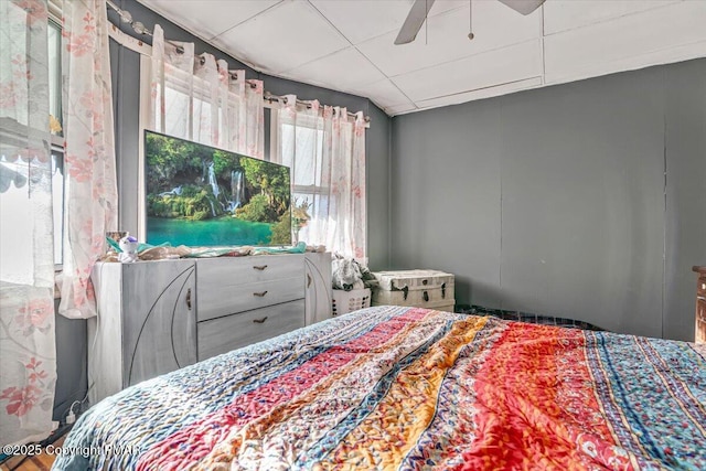 bedroom with a paneled ceiling and ceiling fan