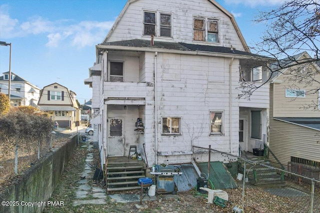 view of front of home featuring fence and a gambrel roof