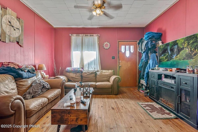 living area with a ceiling fan and hardwood / wood-style flooring