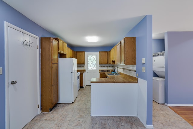3055 Briarwood Dr, Tobyhanna, PA 18466 - kitchen featuring freestanding refrigerator, a peninsula, brown cabinets, and tasteful backsplash