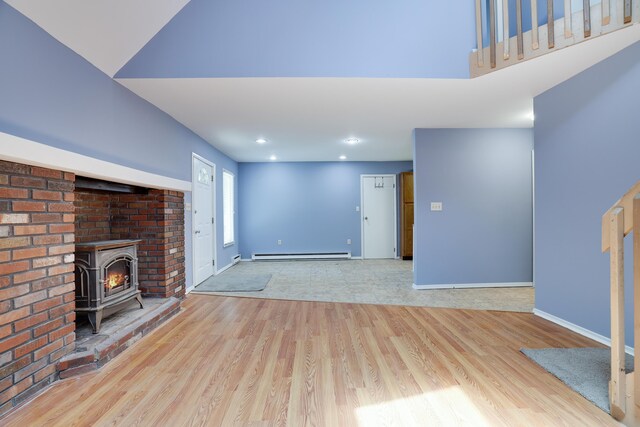 3055 Briarwood Dr, Tobyhanna, PA 18466 - unfurnished living room with a baseboard radiator, wood finished floors, a wood stove, and recessed lighting