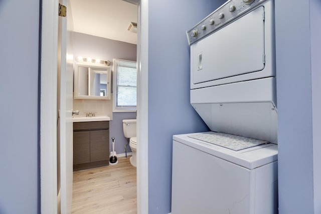 3055 Briarwood Dr, Tobyhanna, PA 18466 - laundry area with stacked washer and clothes dryer and light wood-style flooring