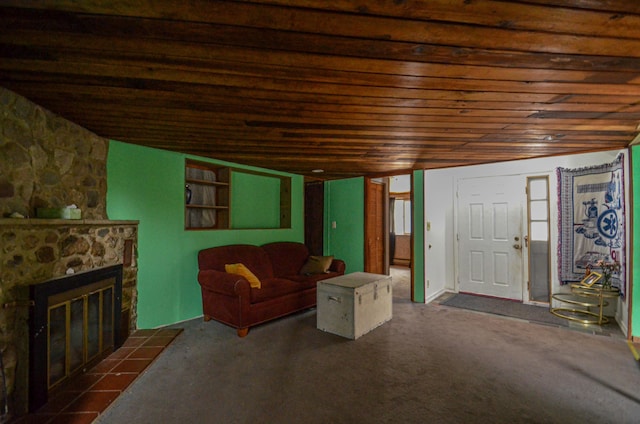 living area featuring dark carpet, a stone fireplace, and wooden ceiling