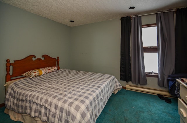 bedroom with a baseboard heating unit, a textured ceiling, and carpet