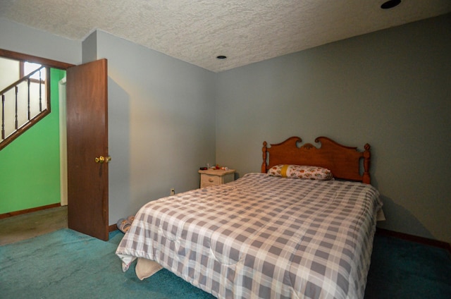 carpeted bedroom with a textured ceiling and baseboards