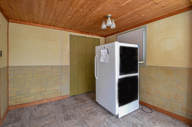 interior space with wooden ceiling and a wainscoted wall