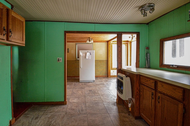 kitchen featuring heating unit, light countertops, and freestanding refrigerator