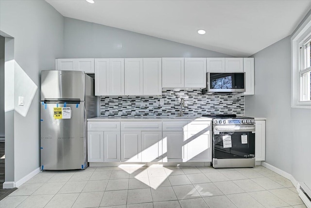 202 Palomino Pl, Tobyhanna, PA 18466 - kitchen with stainless steel appliances, vaulted ceiling, backsplash, a sink, and white cabinets
