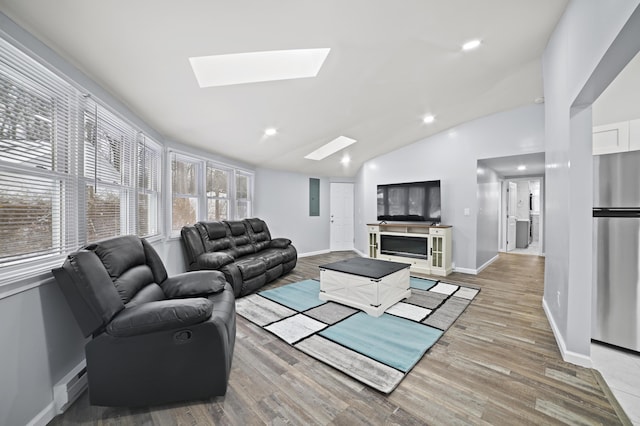 202 Palomino Pl, Tobyhanna, PA 18466 - living room with a skylight, vaulted ceiling, baseboard heating, light wood-style floors, and baseboards