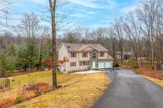 view of front of home featuring aphalt driveway, a front yard, fence, and a garage