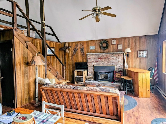 1123 Porter Dr, Bushkill, PA 18324 - living room featuring vaulted ceiling, stairs, a ceiling fan, wood finished floors, and wooden walls