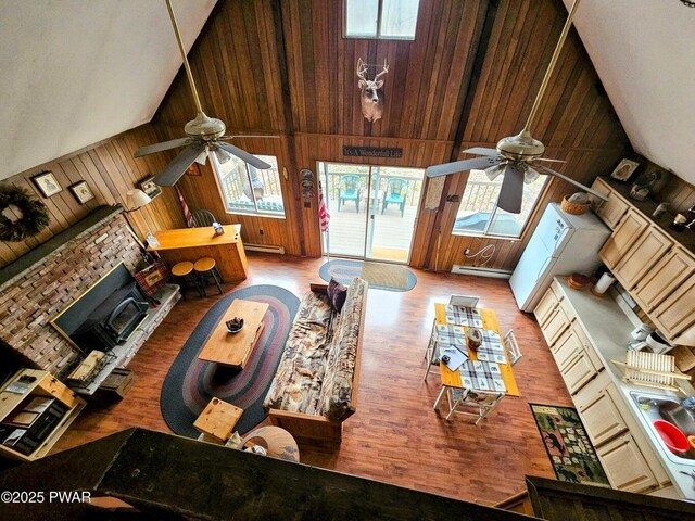 1123 Porter Dr, Bushkill, PA 18324 - living area with a ceiling fan, wood walls, wood finished floors, a baseboard heating unit, and high vaulted ceiling