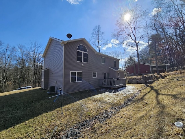 rear view of property featuring central AC, a lawn, and a deck