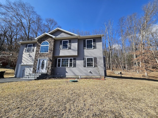 view of front of property featuring a garage, stone siding, aphalt driveway, and a front lawn