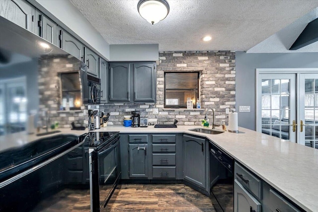 kitchen featuring black appliances, gray cabinets, a sink, and light countertops