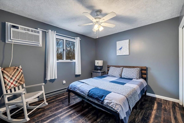 bedroom with a textured ceiling, baseboards, an AC wall unit, and wood finished floors