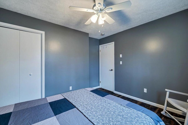 bedroom with ceiling fan, a textured ceiling, baseboards, and wood finished floors