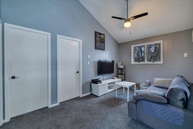 living room with a ceiling fan, dark colored carpet, lofted ceiling, and a textured ceiling