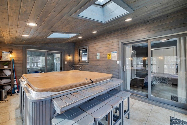 kitchen with recessed lighting, wooden ceiling, vaulted ceiling with skylight, and wooden walls