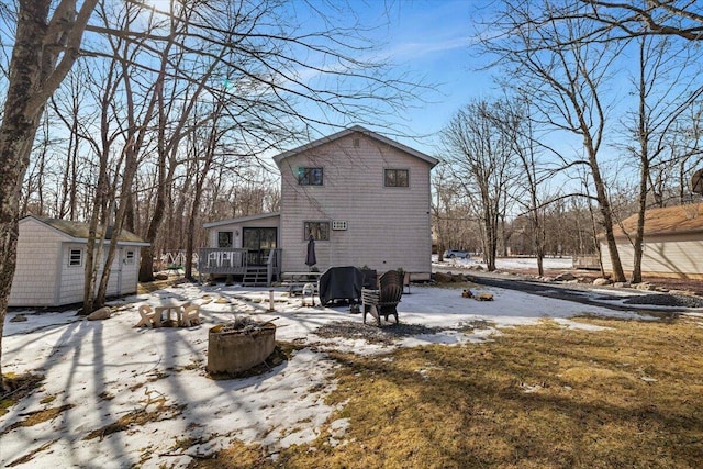 snow covered property featuring an outbuilding and a wooden deck