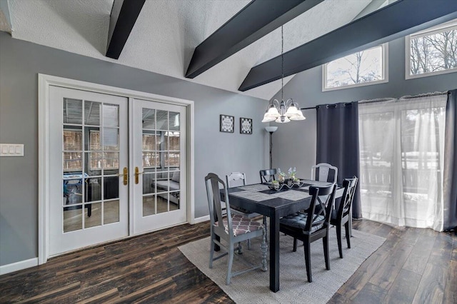 dining space with lofted ceiling with beams, wood finished floors, a textured ceiling, french doors, and a notable chandelier