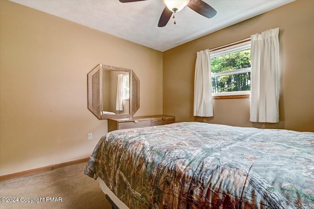 carpeted bedroom featuring baseboards and ceiling fan