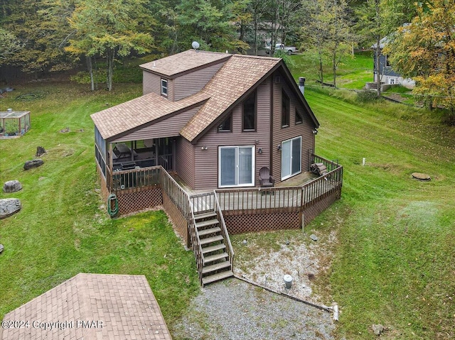 view of front of property with roof with shingles, a wooden deck, a sunroom, stairs, and a front lawn