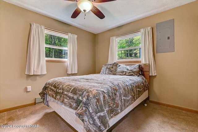 carpeted bedroom with electric panel, ceiling fan, baseboards, and a baseboard radiator